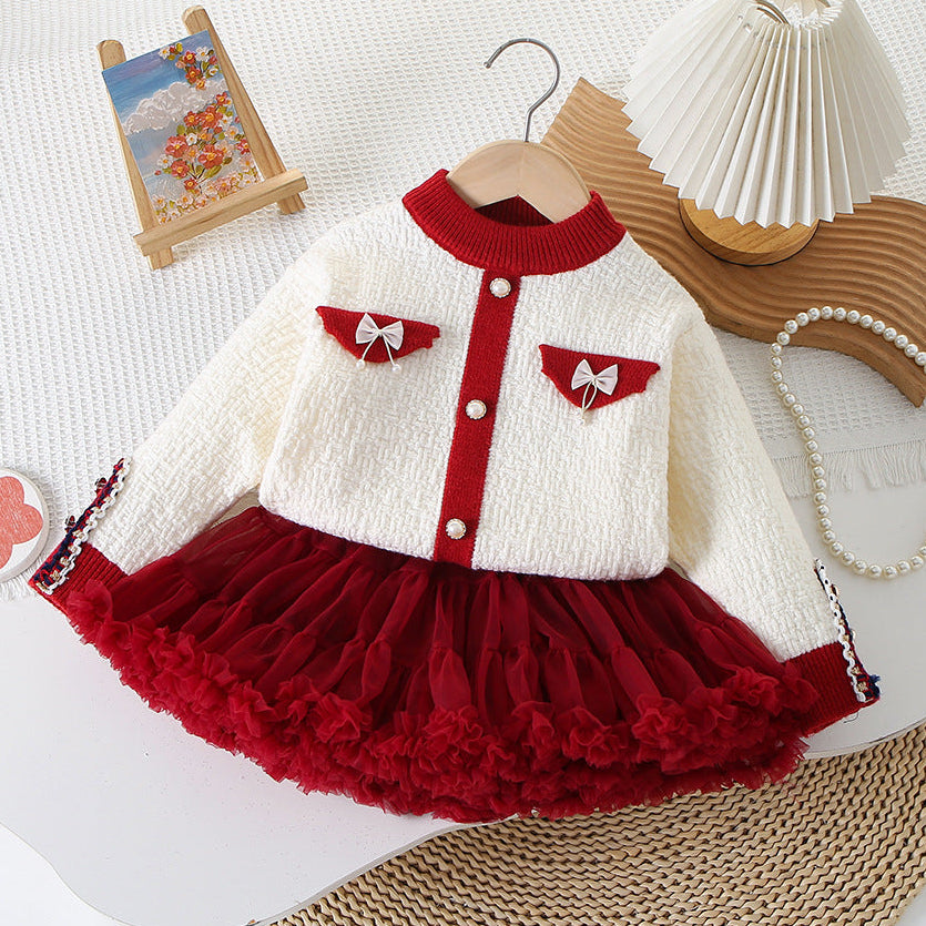 Children's outfit with white sweater and red skirt on a white background