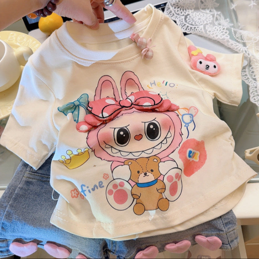 Children's t-shirt with cartoon character design held by a person.